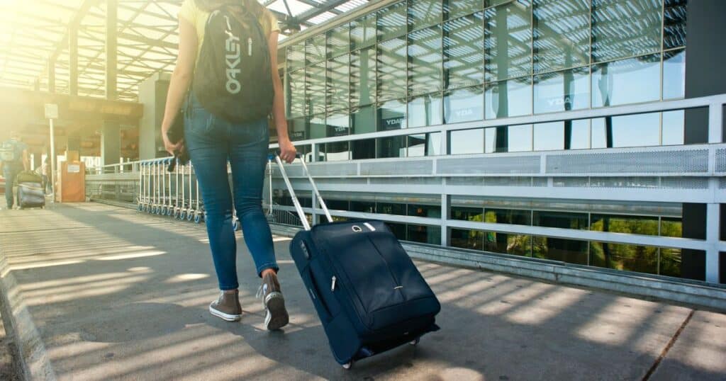 Voyageuse avec une valise souple legere au terminal