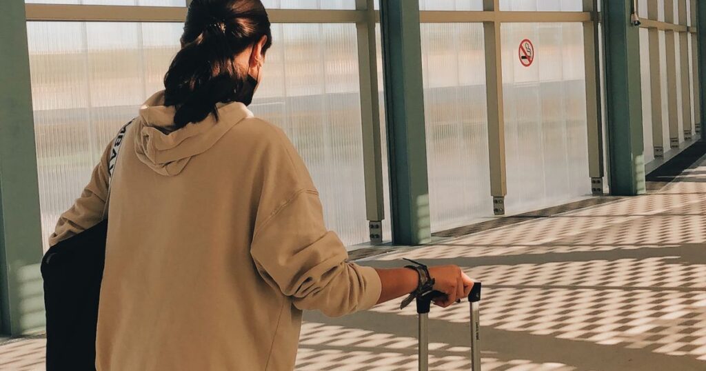 Voyageuse avec sa valise cabine a l aeroport