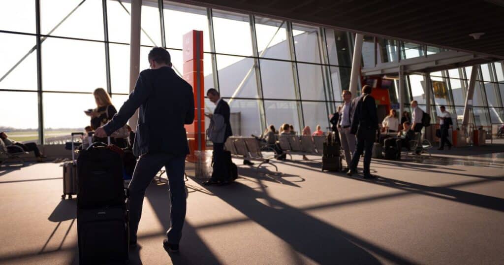 Voyageurs avec valises cabine dans un aeroport