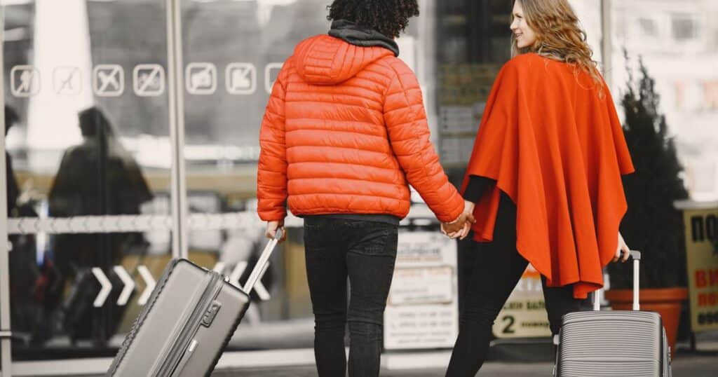 Couple de voyageurs avec de grandes valises a l aeroport